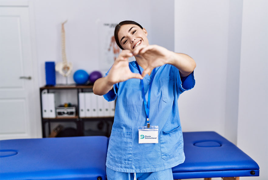 Photo showing a physiotherapist from Germany doing the heart sign with her hands