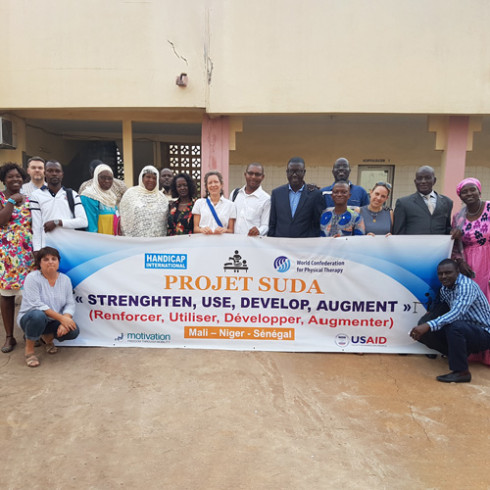 A crowd of people around a banner reading 'Projet SUDA'
